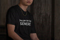 Mand iført sort t-shirt med teksten JEG GØR DET LIGE SENERE — IkkeNu
